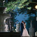 A night shot of a bride and groom outside in front of the fountain on the Columbus Centre grounds.