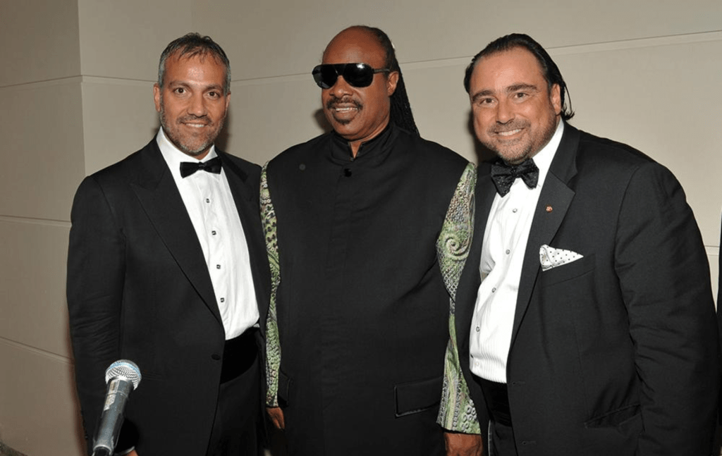 Venetian Ball Co-chairs Steven Muzzo and James Di Luca with Stevie Wonder