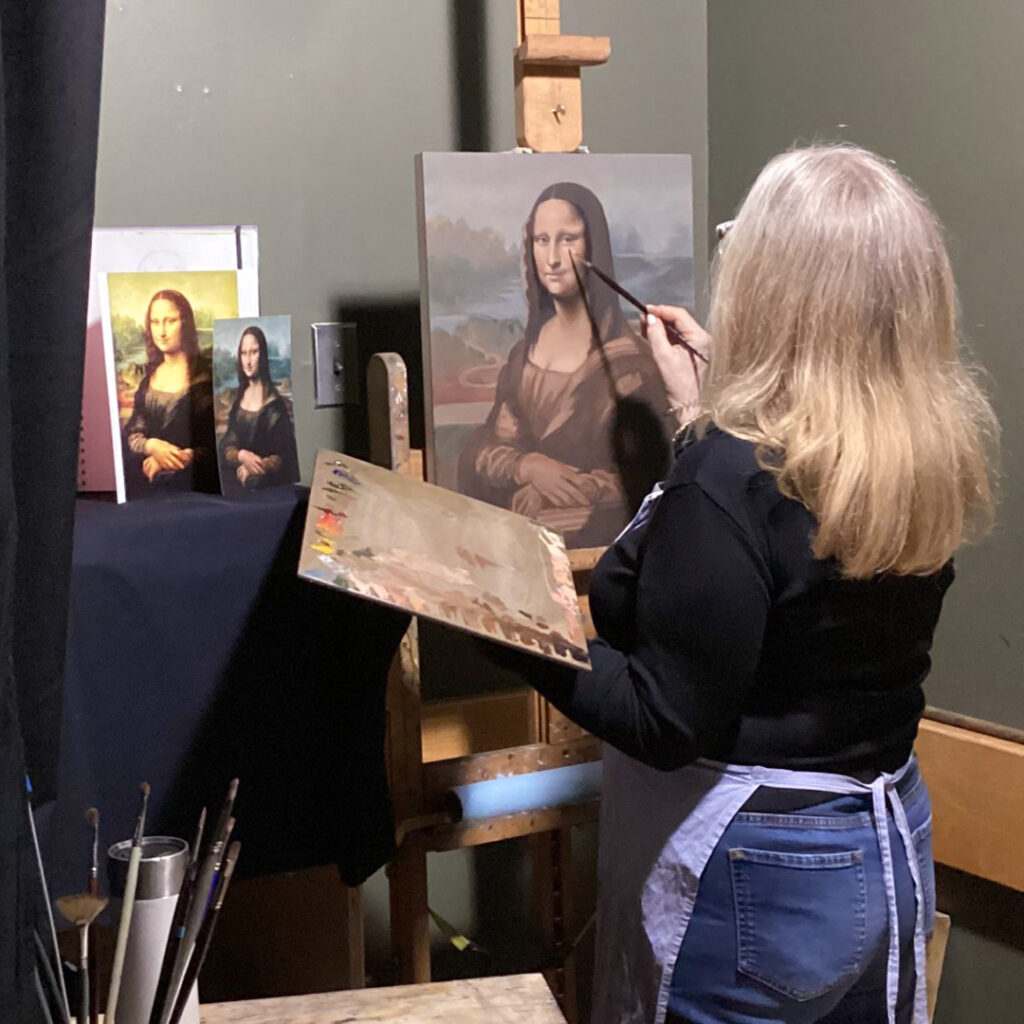 A lady painting a replica of Mona Lisa