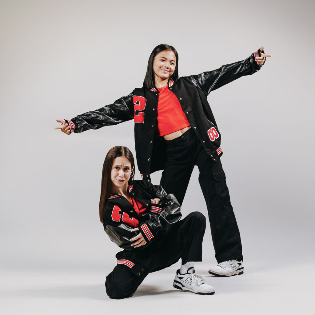 2 teenage girls posing in stylish outfits in a dance studio