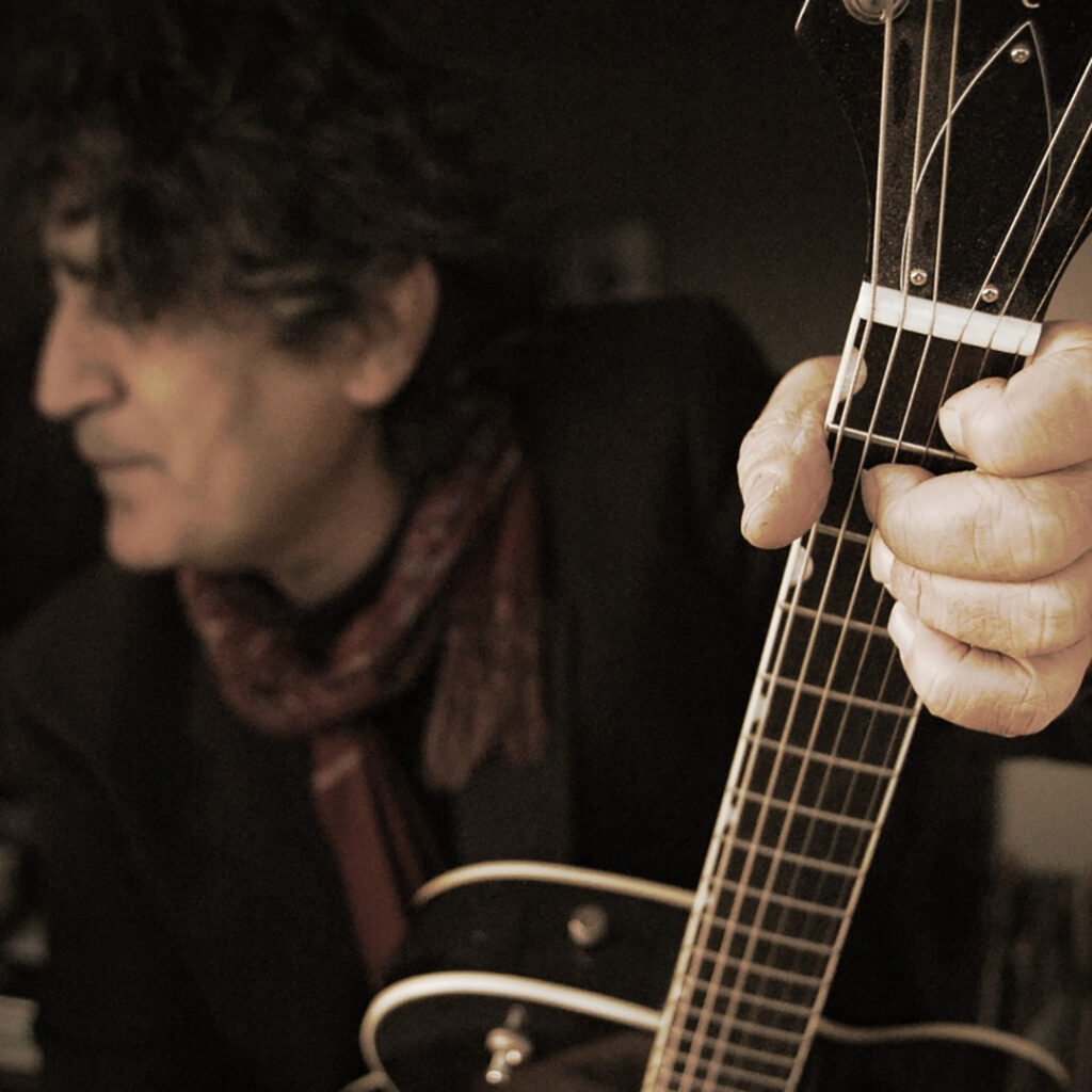 Joseph-Maviglia seen holding a guitar in dark