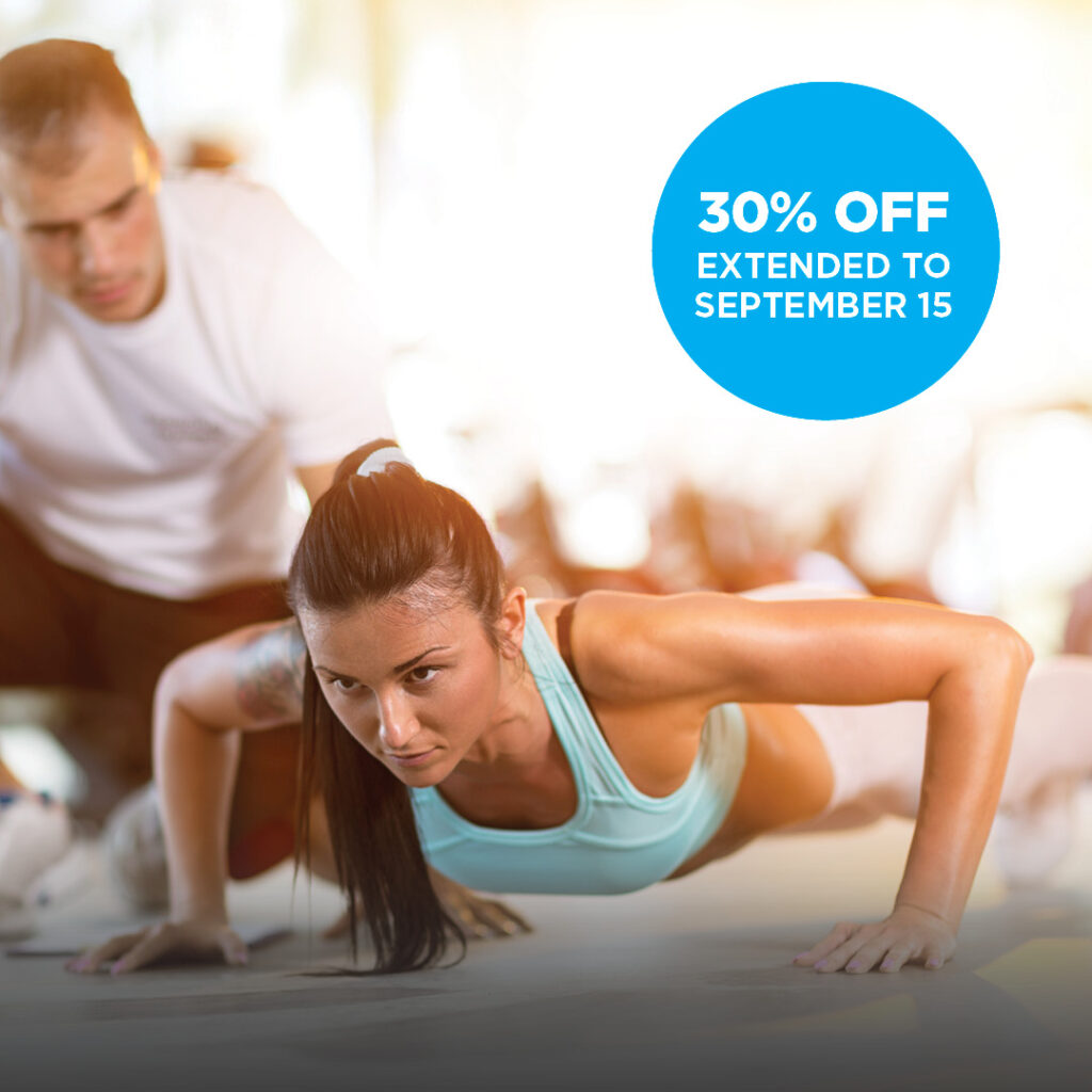 A trainer motivating a woman as she does her pushups