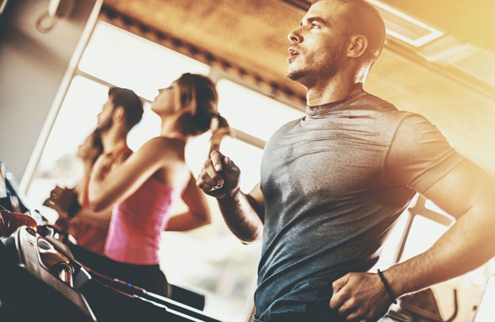 Group of people running on treadmills.