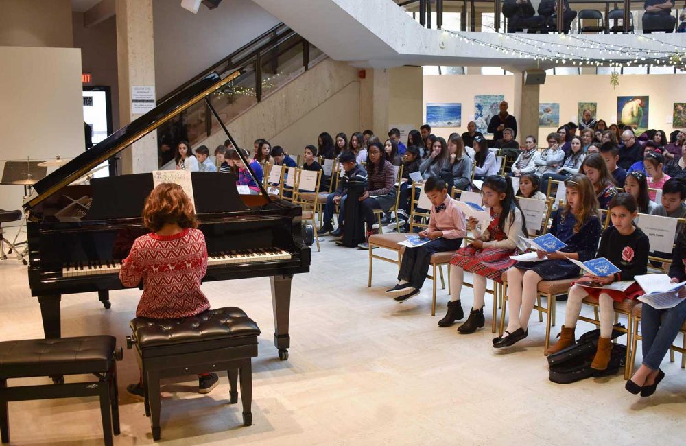 A student plays the piano at a Columbus School of Music recital.