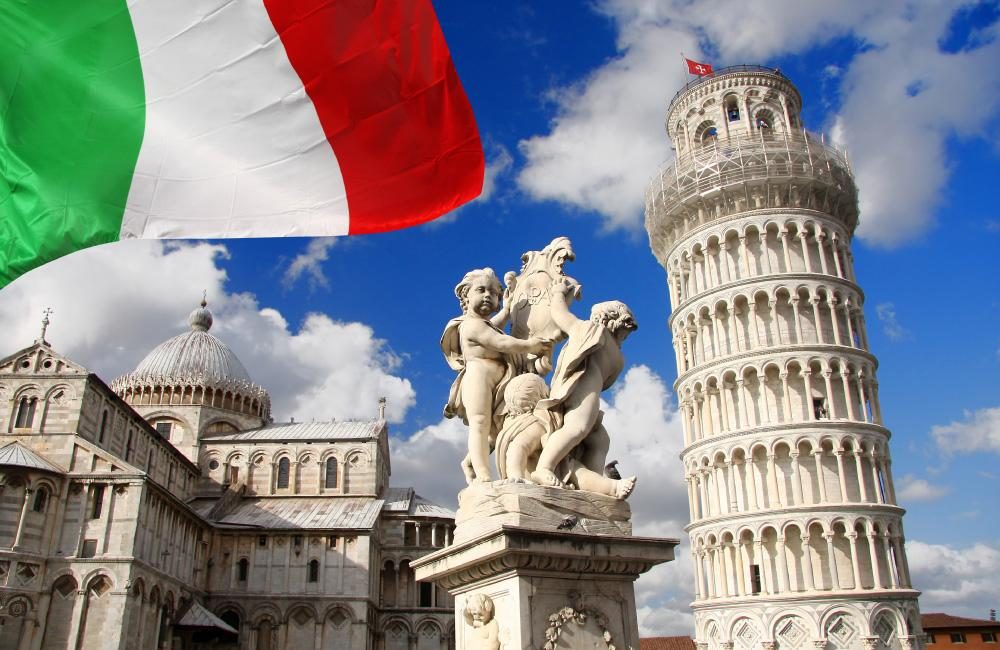 The Leaning Tower of Pisa, a statue, and the Italian flag in Pisa, Italy.